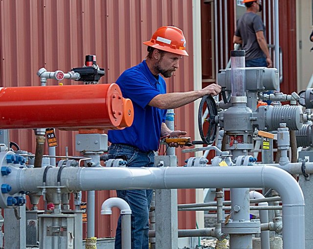 worker in field working on equipment