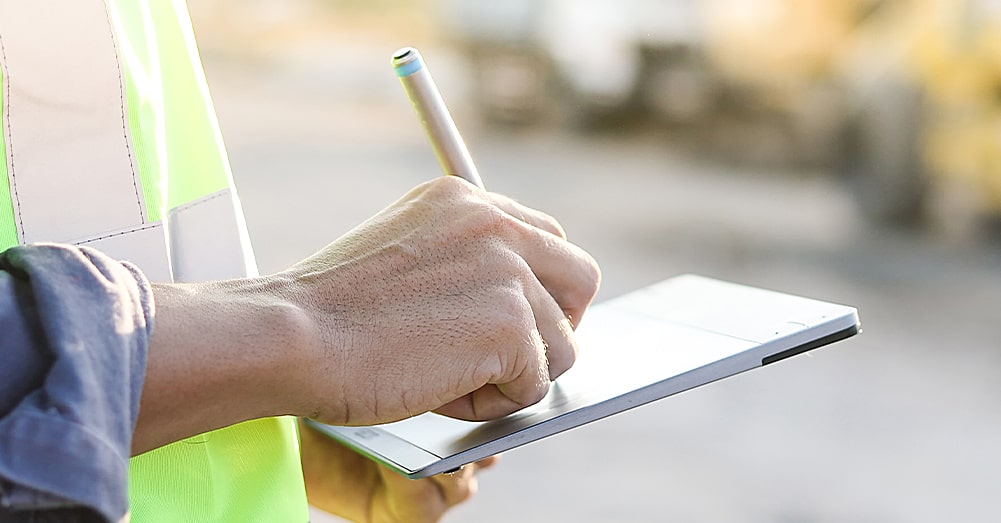 Man writing on notepad on-site