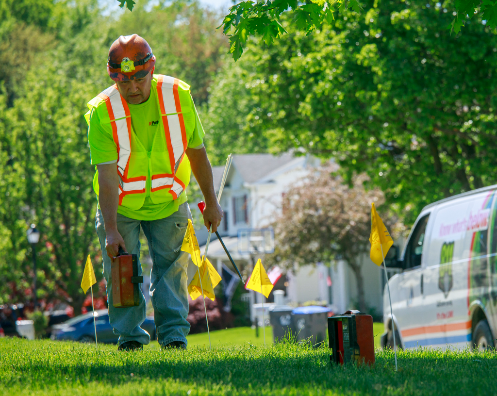 utility worker marking underground pipeline with flags