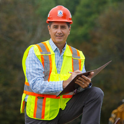 man with paper and pen in hard hat