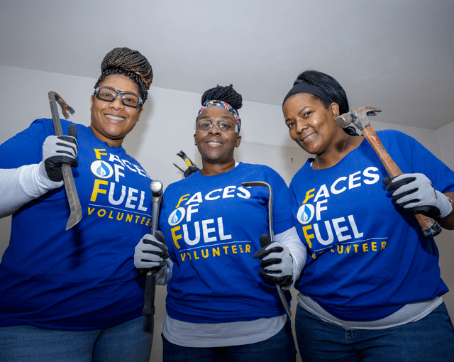 three women with hammers and safety goggles at a volunteer event