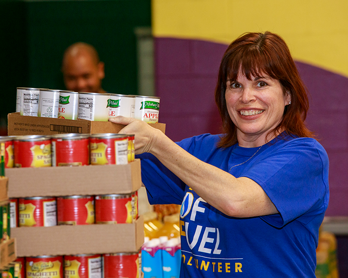 woman stacking canned goods at a soup kitchen